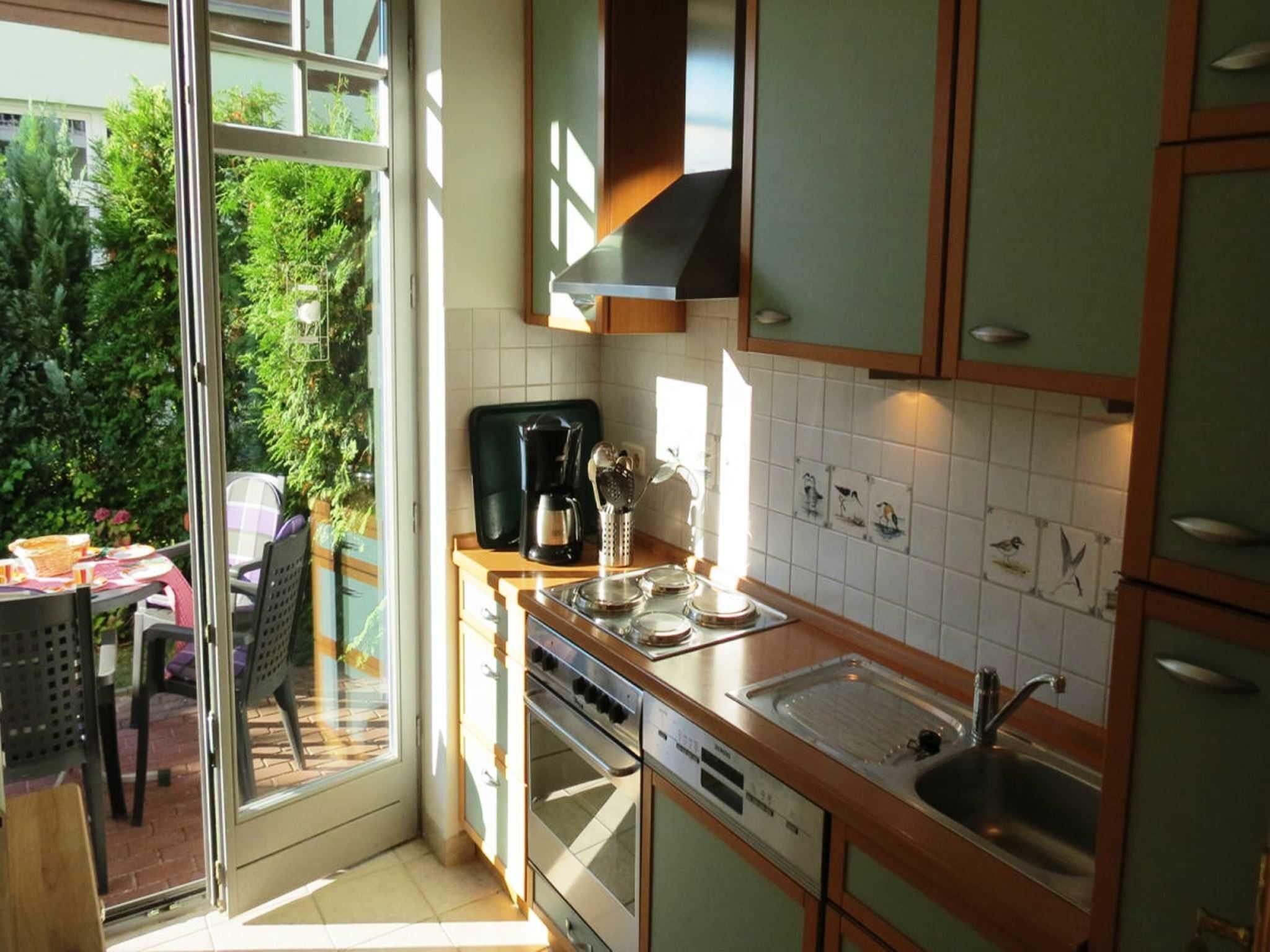 A kitchen with a large window, a coffee maker, and a sink.