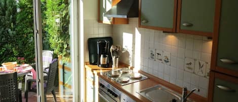 A kitchen with a large window, a coffee maker, and a sink.