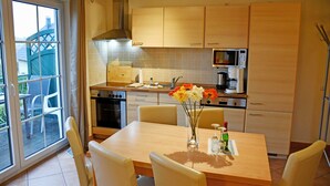 Una cocina moderna con comedor, que cuenta con un amplio ventanal, un microondas y una estufa.