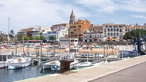 A marina with boats docked, a prominent church tower, and a mix of residential and commercial buildings. - Beautiful apartment in Palamós (Palamós)