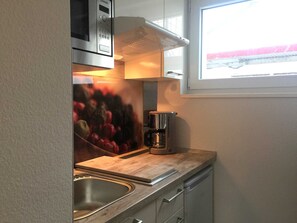 Køleskab, mikrobølgeovn, højstol, spisebord