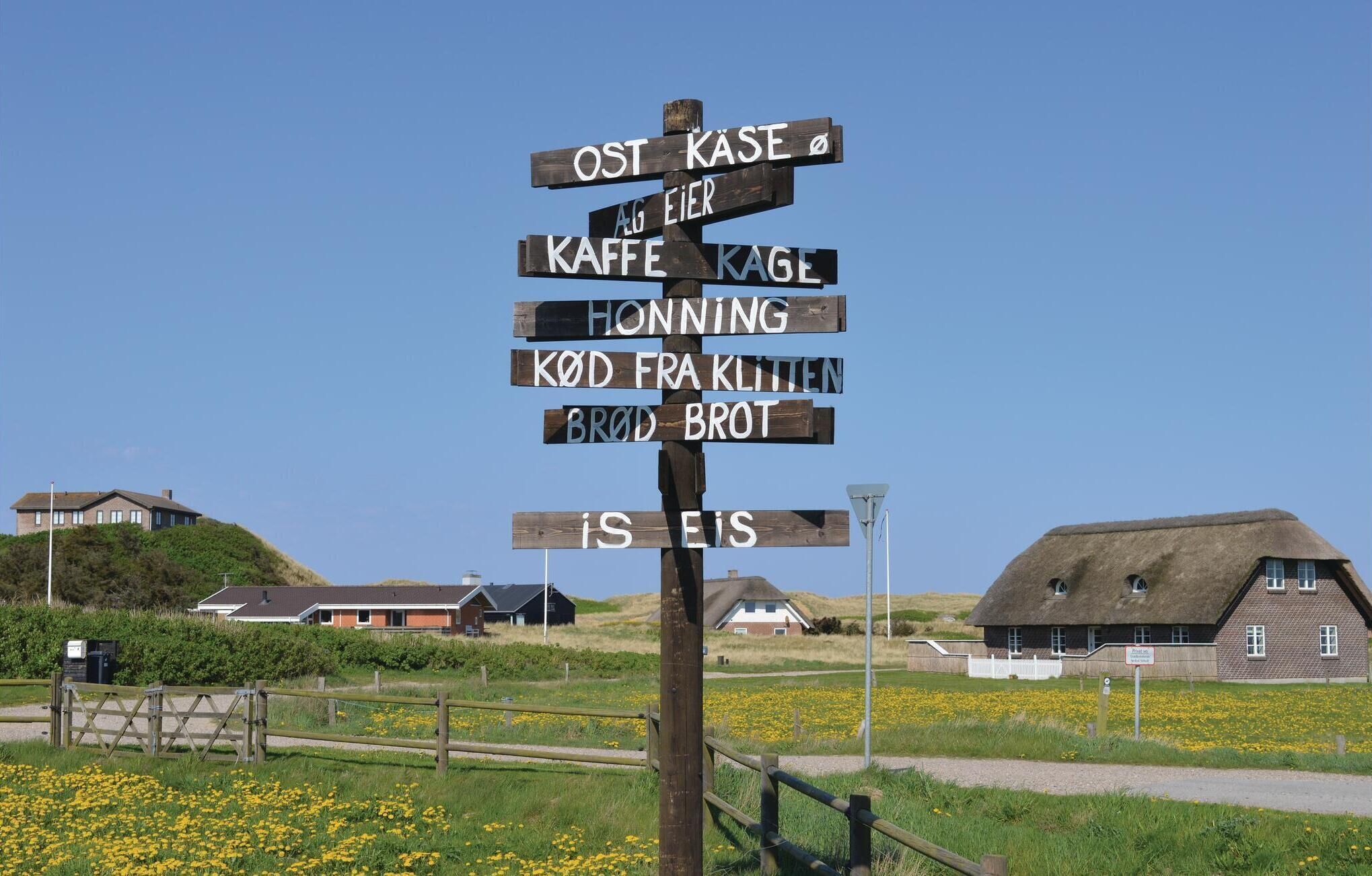 A wooden signpost with multiple directional signs in a rural setting.