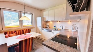 Una cocina compacta con comedor, cafetera y lavamanos.