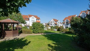 A residential area with houses, a gazebo, and a well-maintained lawn.