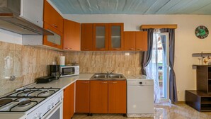 A compact kitchen with a gas stove, microwave, sink, and dishwasher. - Beautiful home in Zminj (Zminj)