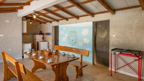 A dining area with a wooden table set for four, benches, a red metal cart, and a kitchen in the background. - Beautiful home in Zminj (Zminj)
