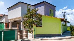 A two-story house with a green and white facade, a small porch, and a green gate. - Beautiful home in Zminj (Zminj)