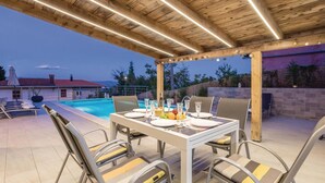 An outdoor dining area with a pool, wooden ceiling, and a view of a house in the background. - Stunning home in Lovran with private swimming pool, can be inside or outside (Lovran)