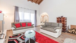 A living room with two grey sofas with red cushions, a glass coffee table, and a red rug. - Stunning home in Lovran with private swimming pool, can be inside or outside (Lovran)