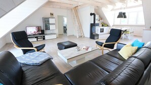 Ein moderner Loft-Wohnraum mit Schlafgalerie, Essbereich und Küche.