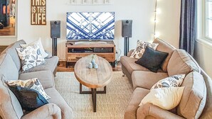 A living room with two sofas, a coffee table, and a television. There are speakers on either side of the TV. - Gorgeous home in årjäng with WiFi (Årjäng)
