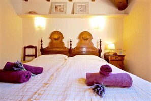 A double bed with a wooden headboard, two bedside tables, and a wall-mounted light fixture. - 44252 Finca Son Homar (license number ET / 3279) - 44252 Finca Son Homar (Petra)