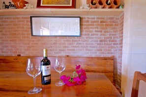 A wooden table with a bottle of wine, two glasses, and a bouquet of flowers. - 44252 Finca Son Homar (license number ET / 3279) - 44252 Finca Son Homar (Petra)