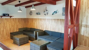 Una stanza con mobili in vimini, una ventola a soffitto e decorazioni alle pareti.