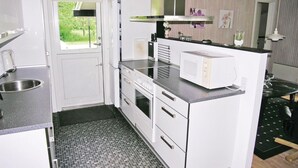 Une cuisine compacte équipée d’un four à micro-ondes, d’un four traditionnel et d’un évier.