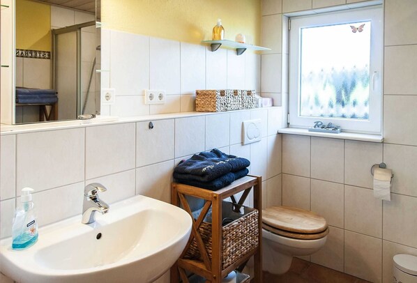 Un baño con lavamanos, inodoro y ventana con vistas.