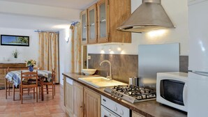 A compact kitchen with wooden cabinets, a gas stove, a microwave, and a sink. - Nice apartment in La Valette du Var (La Valette du Var)