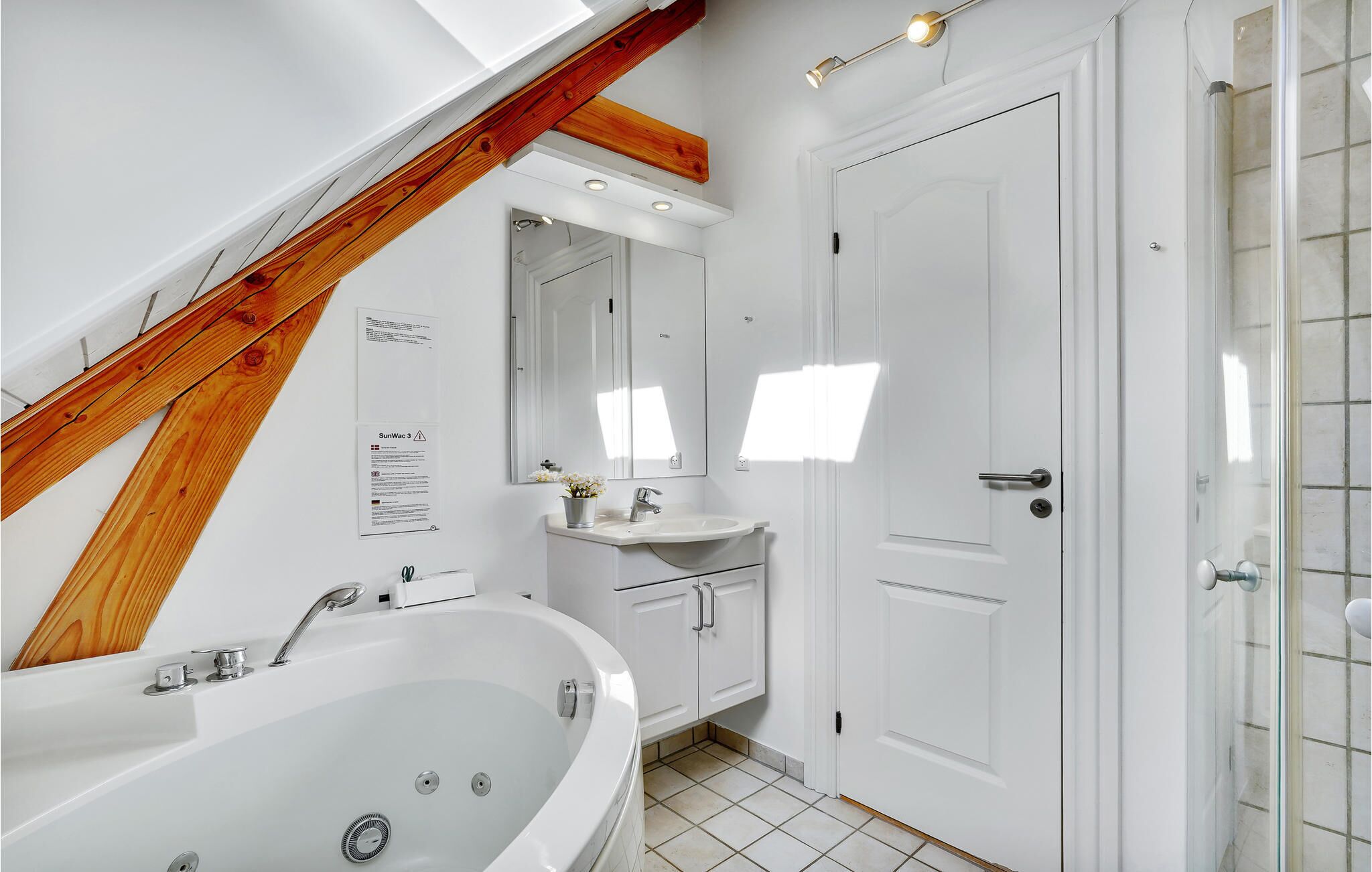 A modern bathroom with a freestanding bathtub, a vanity with a mirror, and a shower area.