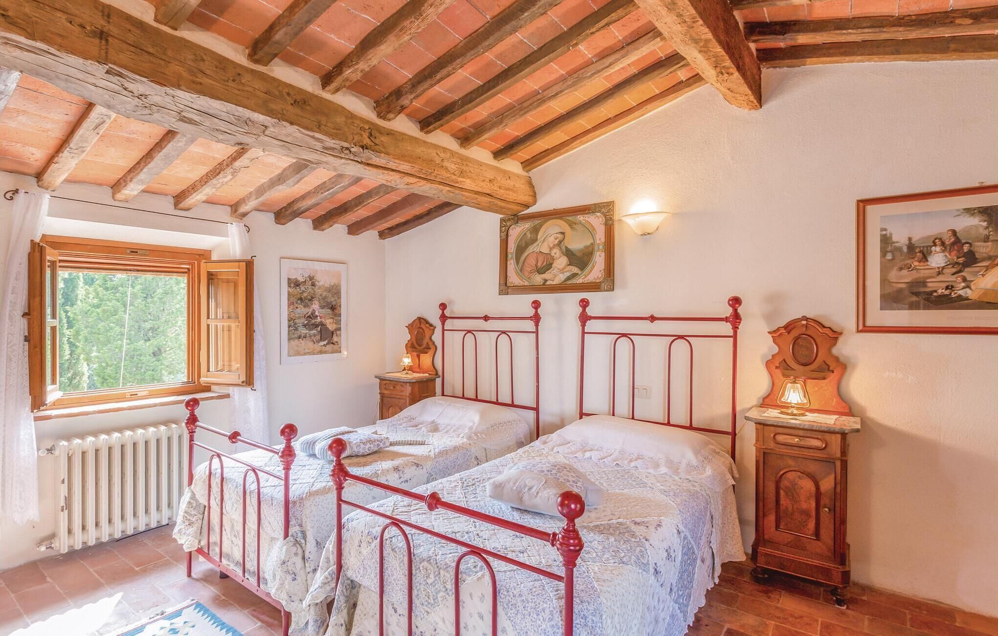 Ein Schlafzimmer mit zwei Einzelbetten, einem Heizkörper, einem Fenster und einem Bild an der Wand.