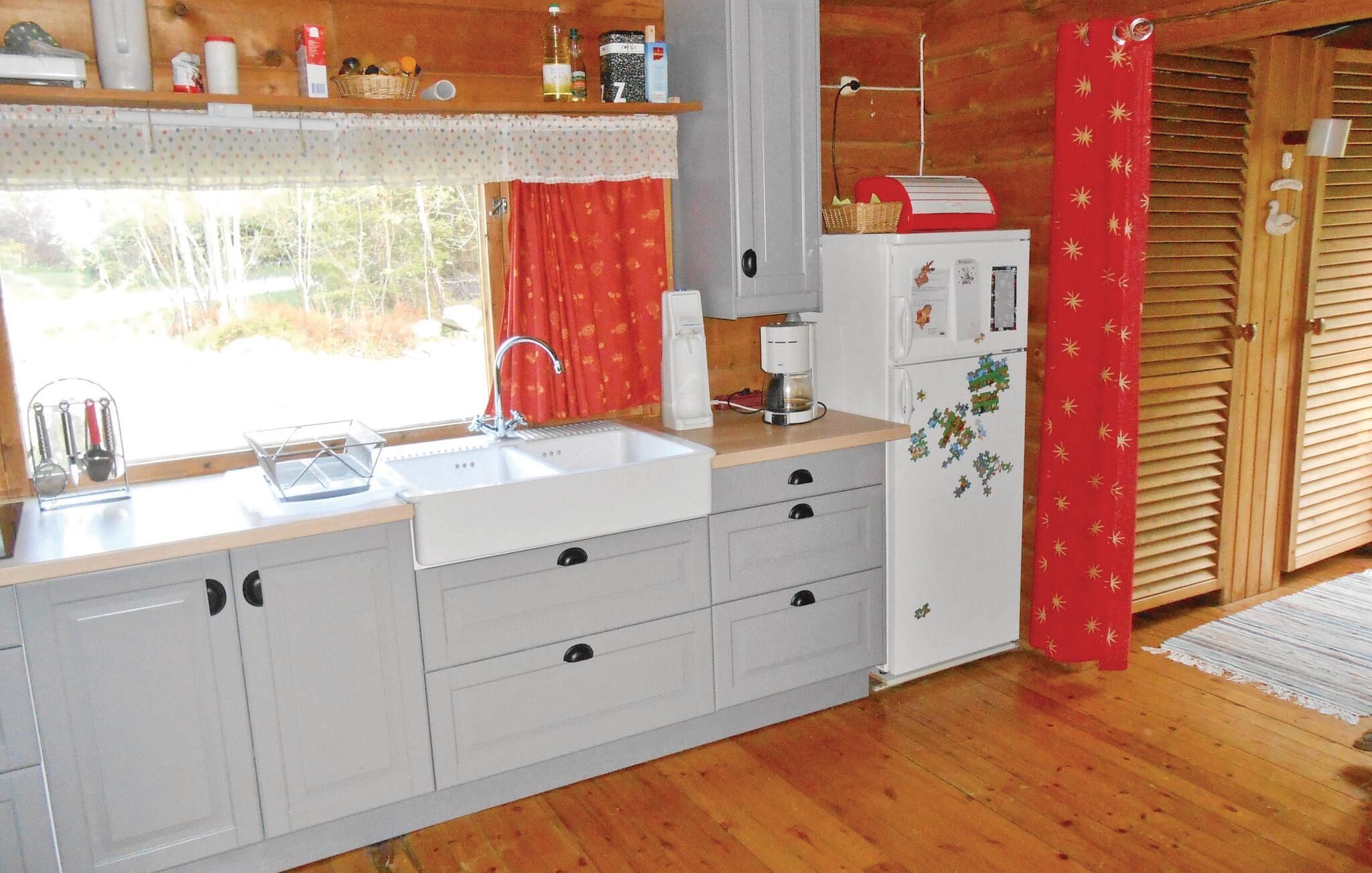 A kitchen with a sink, a coffee maker, and a refrigerator.