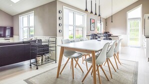 Une cuisine moderne avec un coin repas, de grandes fenêtres et un téléviseur.