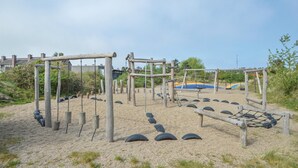 Een speeltuin met houten constructies en banden als speeltoestellen.