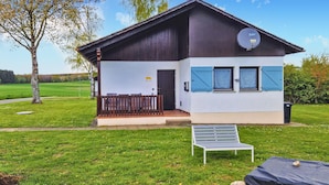 A modern building with a satellite dish, a small porch, and a bench in front.
