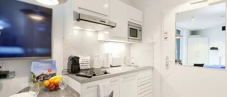 Enjoy cooking in this well-equipped kitchen with a microwave, stainless steel range hood, and flat-screen TV.