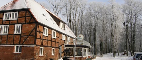 Un bâtiment traditionnel à colombages portant une enseigne indiquant « Lübzer Ferienhaus Insels Hotel ».