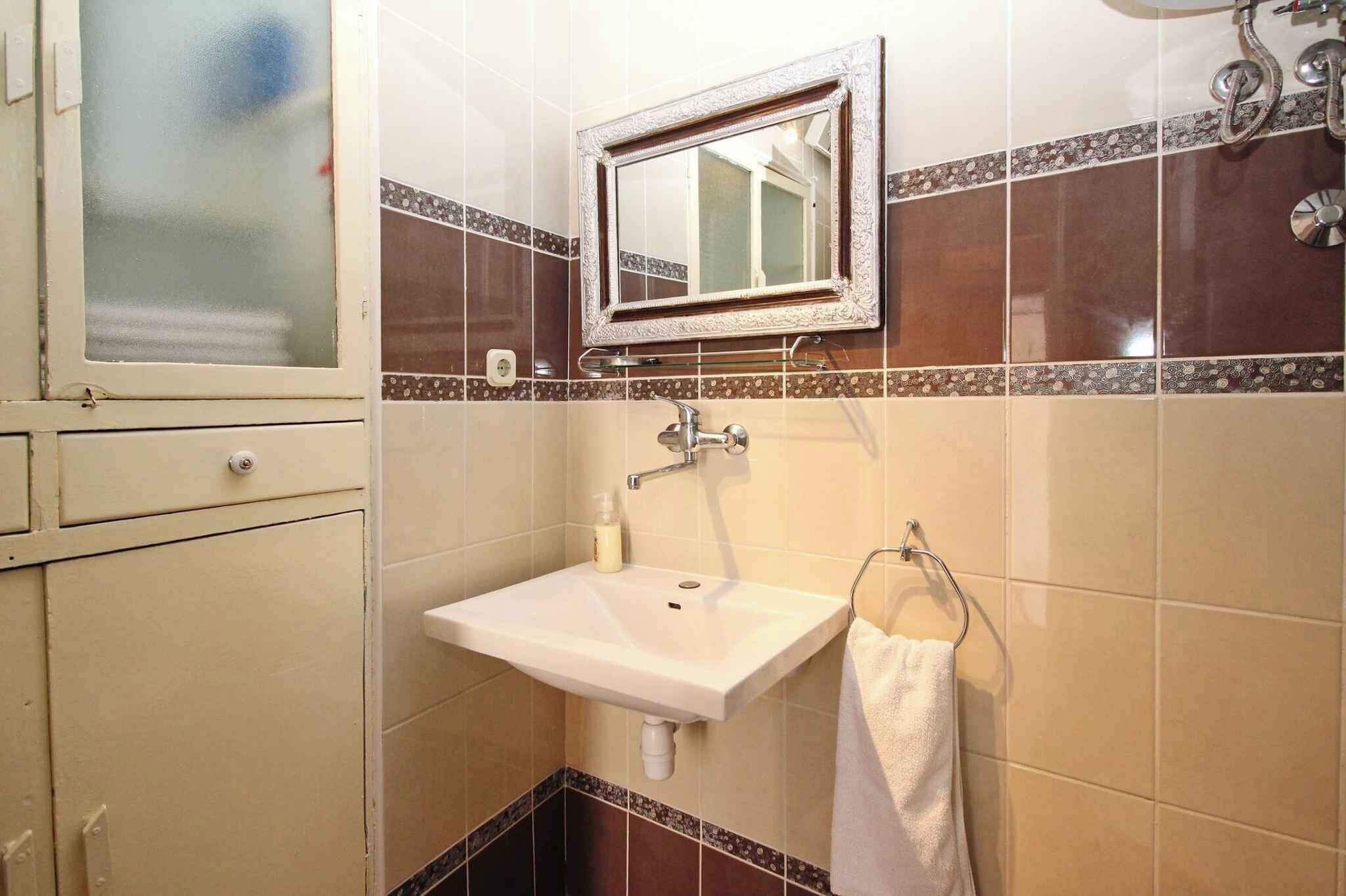A bathroom with a sink, mirror, and towel rack.