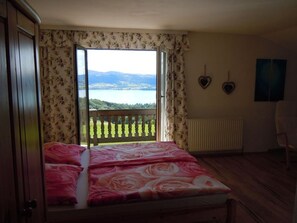 Un dormitorio con cama, vistas a un lago, un radiador y una silla.