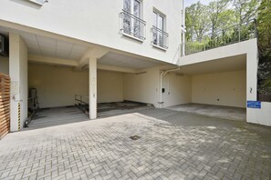 A building with a covered entrance, a staircase, and a paved courtyard.