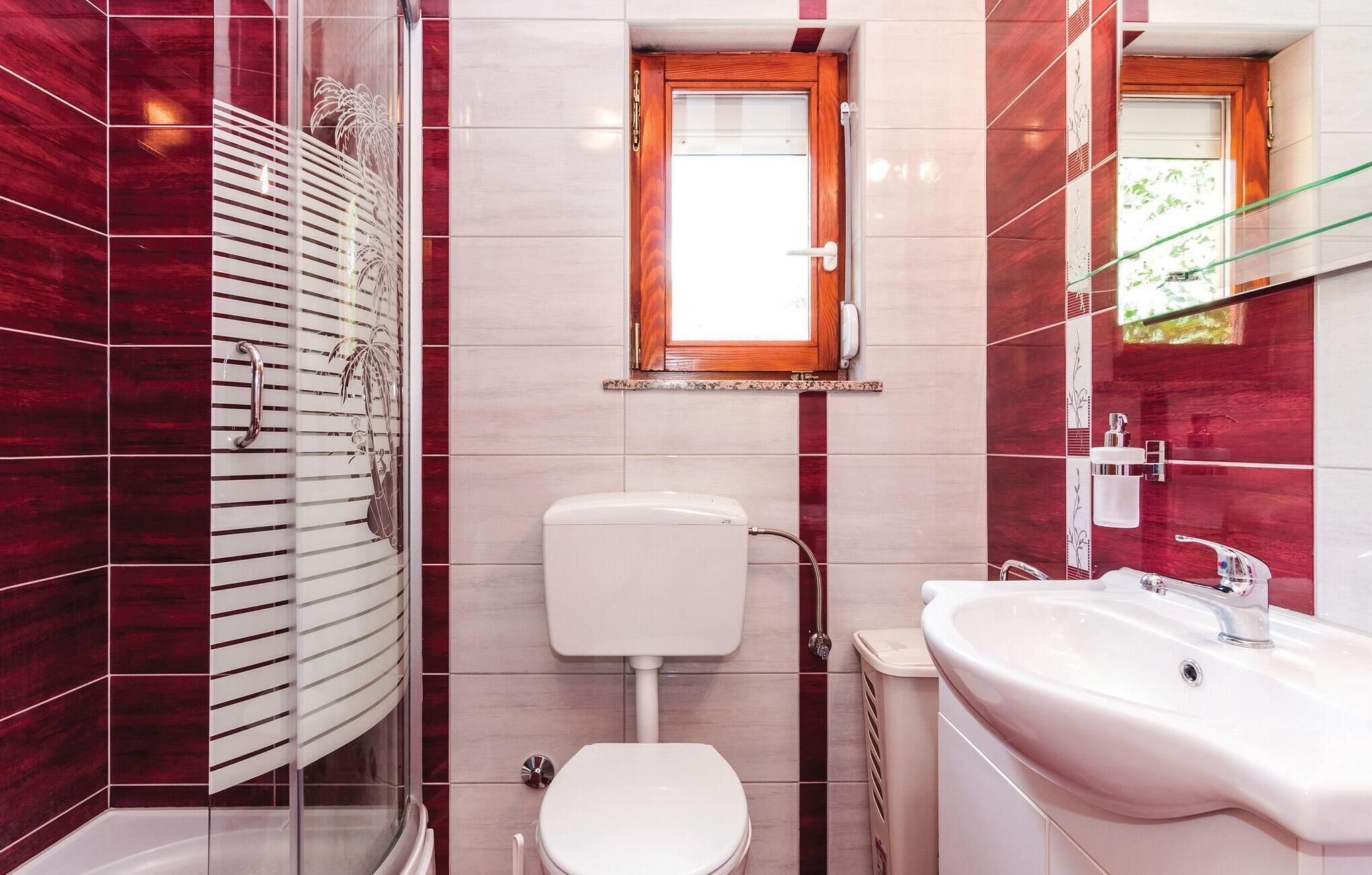 Een badkamer met toilet, wastafel en douche.