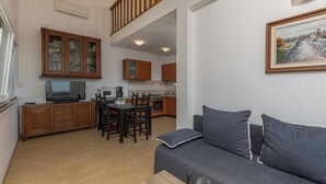 A modern apartment with a dining area, kitchen, and living room. - Beach front apartment in Njivice with WiFi (Njivice)