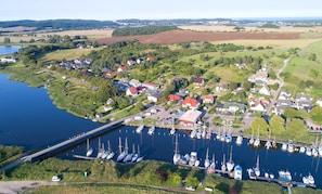 Ein Yachthafen mit vertäuten Booten, umgeben von Wohnhäusern und viel Grün.
