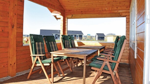 A wooden deck with a table and chairs, overlooking a residential area. - Lovely home in Sydals with sauna (Sydals)