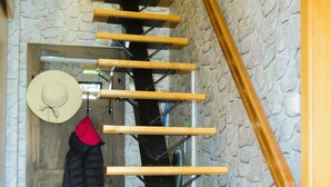 Un escalier en colimaçon avec des marches en bois et un mur en pierre en arrière-plan.