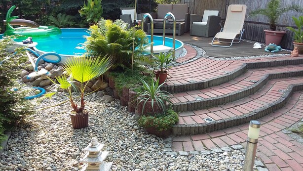 A backyard with a swimming pool, outdoor furniture, and a stone staircase leading to a patio area. - Vacation apartment Lotti, Germany (Lutherstadt Wittenberg)