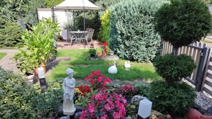 A garden with a statue, a gazebo, and various plants. - Vacation apartment Lotti, Germany (Lutherstadt Wittenberg)