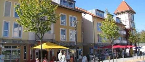 A street with buildings, outdoor seating, and bicycles.