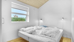 Una camera da letto con un letto, una finestra e due luci fissate al muro.