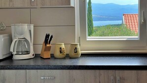 Una cocina con cafetera, bloque de cuchillos y dos frascos sobre la encimera.