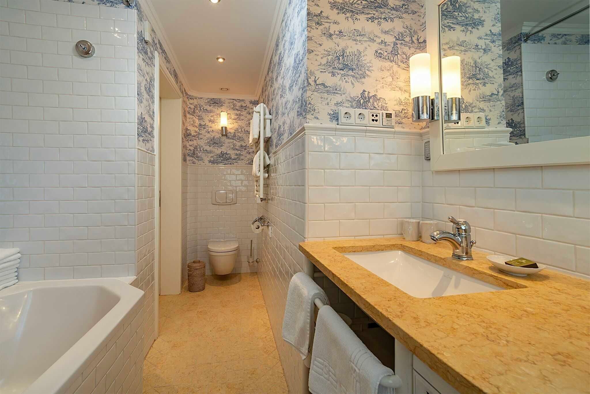 Ein Badezimmer mit Badewanne, Waschbecken mit Spiegel und Toilette.