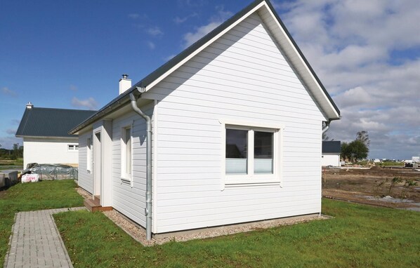 A white single-story house with a gable roof, a front door, and a small window. - Pet friendly home in OstseeResort Olpenitz with sauna (OstseeResort Olpenitz)