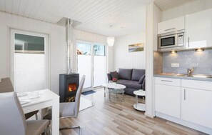 A modern kitchen with white cabinetry, a built-in microwave, and a stainless steel range hood. - Pet friendly home in OstseeResort Olpenitz with sauna (OstseeResort Olpenitz)