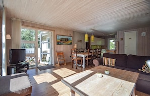 A spacious living area with a wooden floor, a dining table, and a sofa. There is a television and a painting on the wall. - Cozy home in Rømø with WiFi (Rømø)