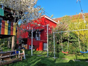 Ein rotes Gebäude mit Schaukel und Wäscheleine im Hof.