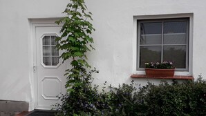 Un bâtiment blanc avec une porte et une fenêtre.