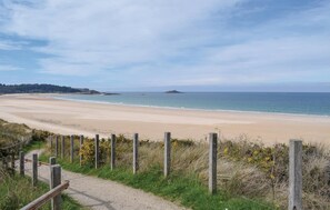 A coastal beach with a sandy shore, a wooden fence, and a path leading to the beach. - 1 bedroom cozy apartment in Matignon (Matignon)