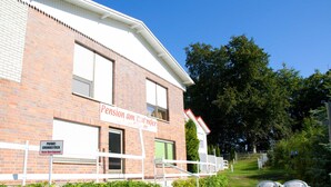 A building with a sign reading "Pension am Hohen". - Sun view with sun terrace 5 min to the Baltic Sea and beach (Sellin)